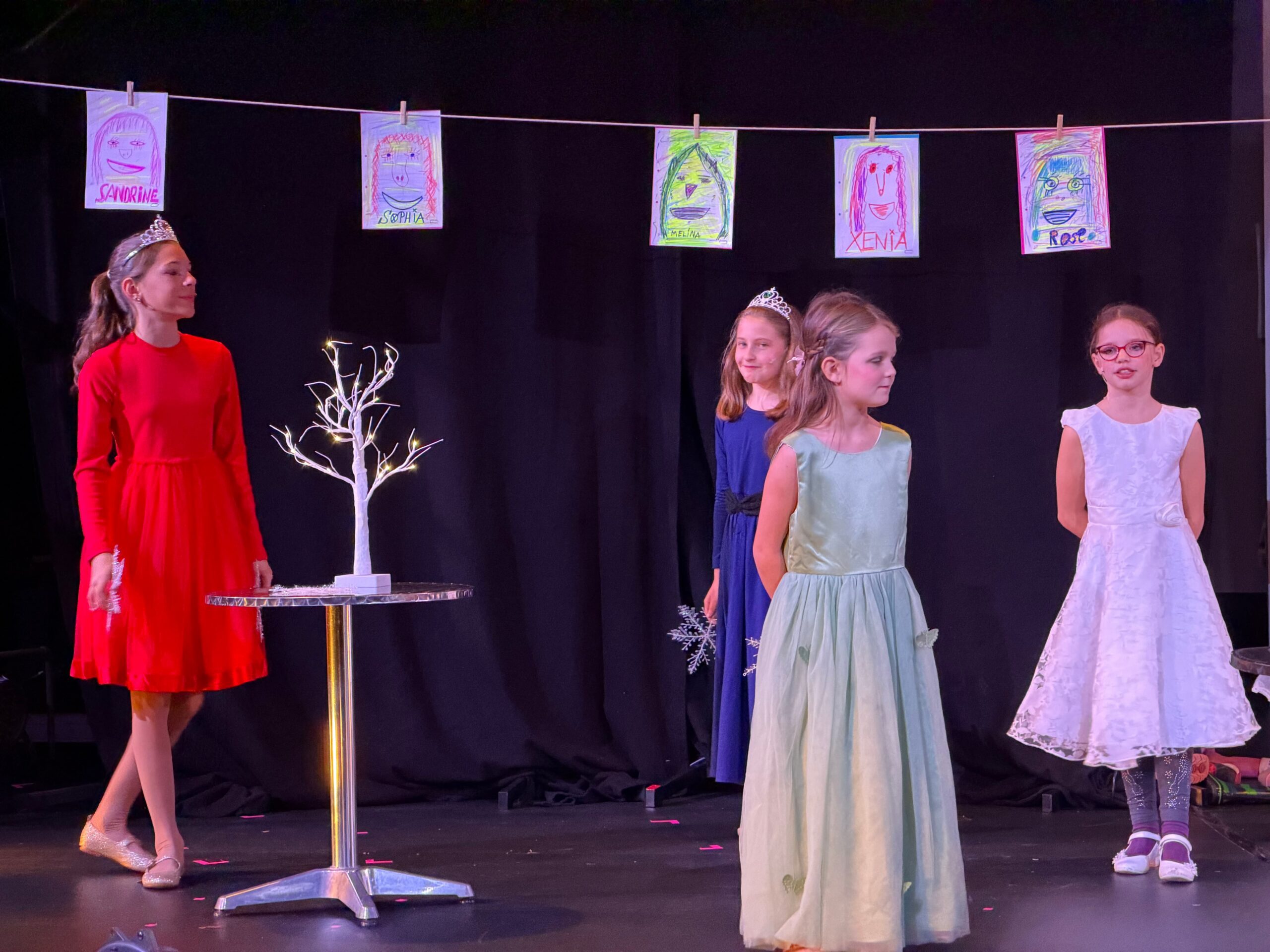 4 Mädchen in bunten Kleidern stehen auf der Bühne