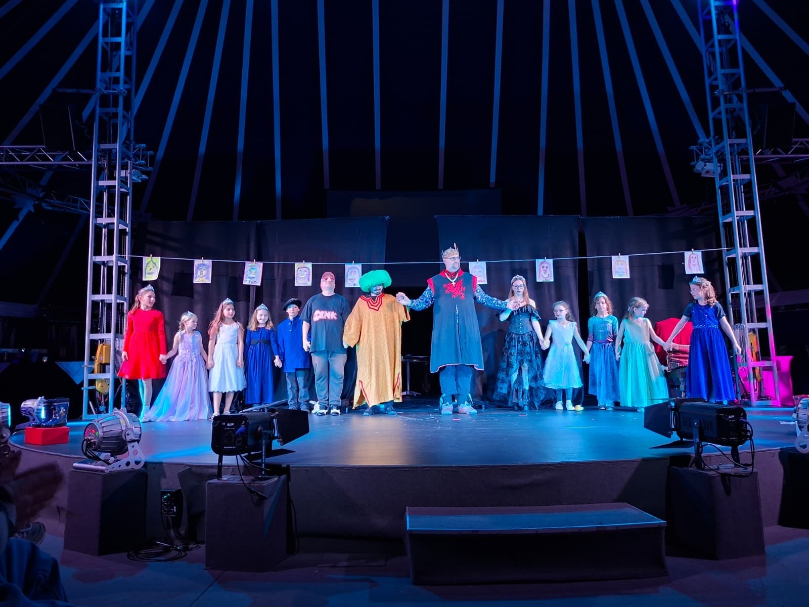 Die Kinder und erwachsenen Schauspielerinnen und Schauspieler des Stücks "Die zertanzten Schuhe" stehen auf der Bühne in Kostümen zum Schluss.