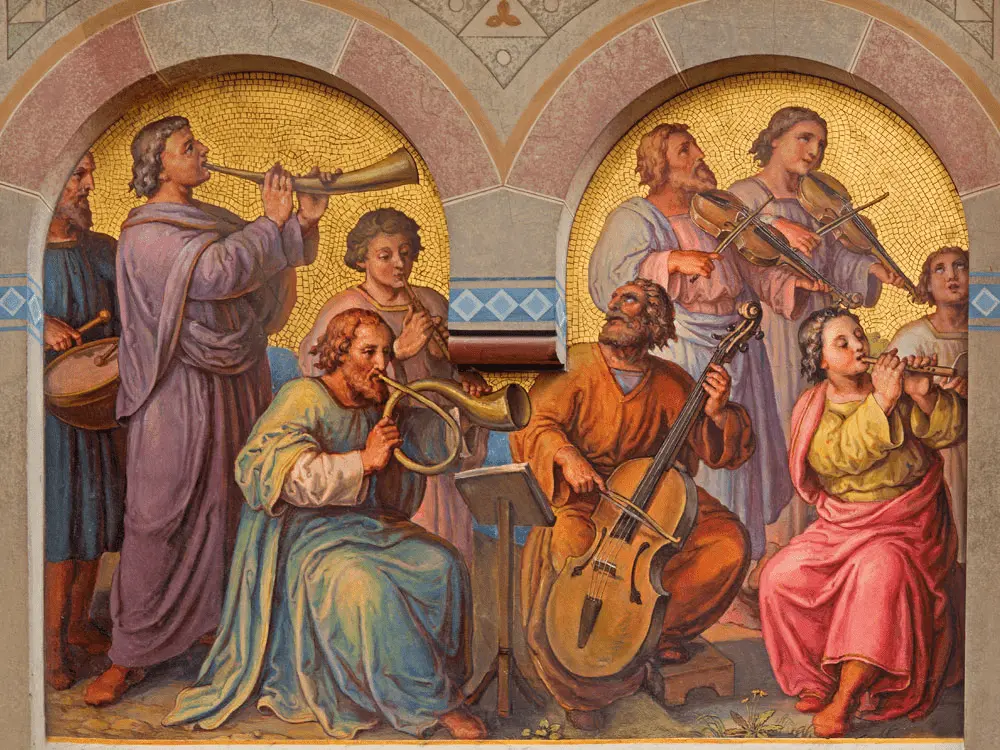 Ein Wandgemälde zeigt neun Menschen, die vor einem goldenen Hintergrund, der von zwei Bögen eingerahmt wird, Musikinstrumente spielen, darunter Geigen, Trompeten, ein Cello, eine Flöte und eine Trommel.